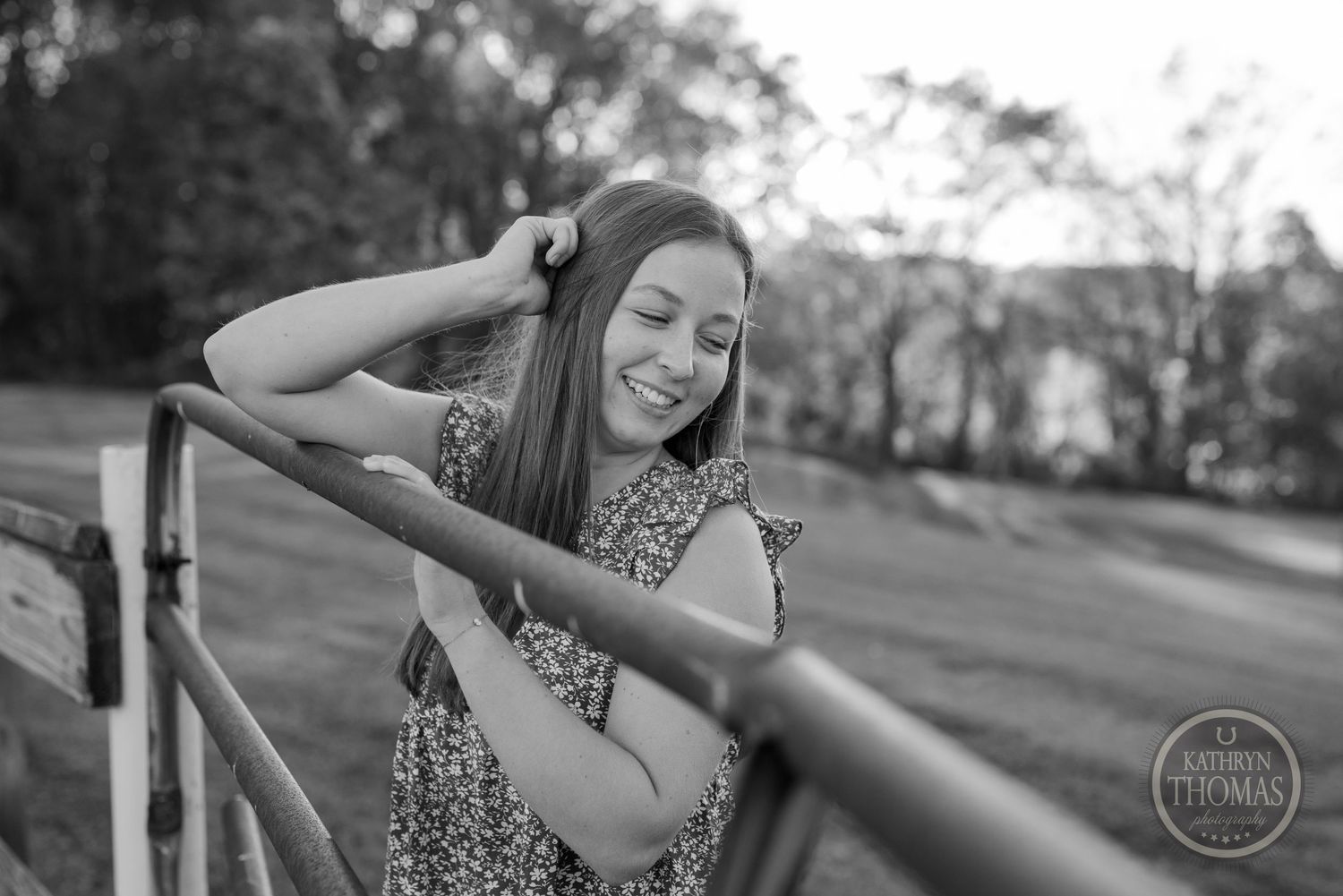 A black and white portrait shows someone posing by a fence with natural expressions.