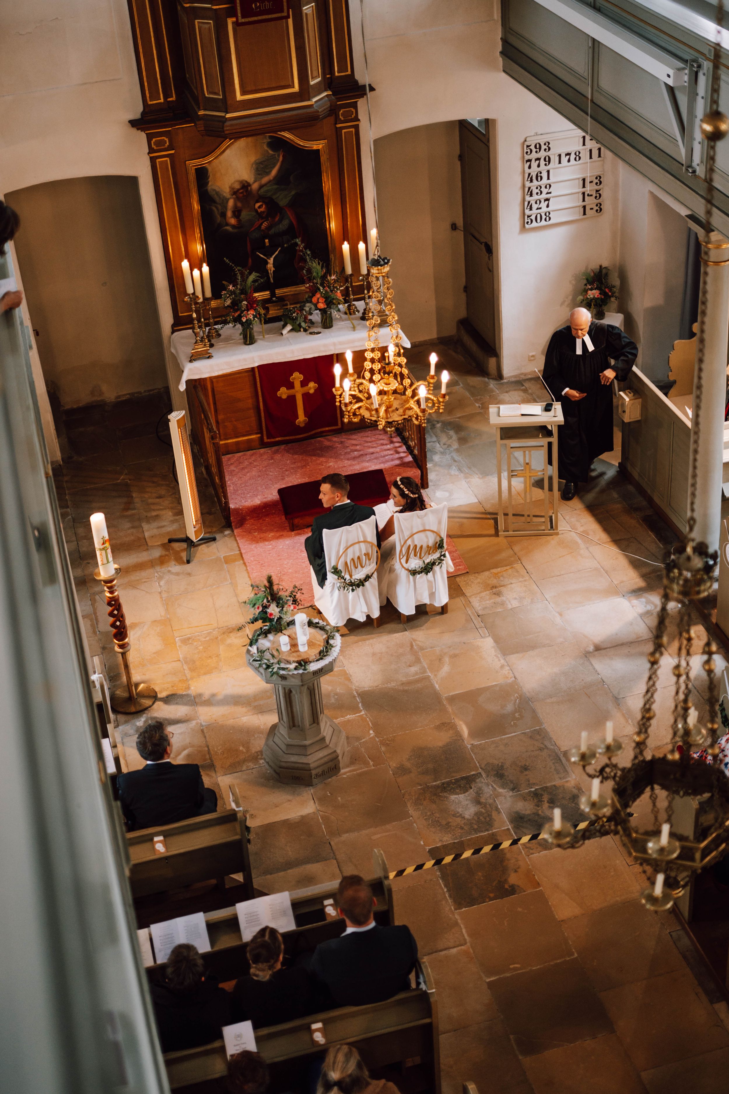Aerial view of a church wedding ceremony with candles and traditional decor.