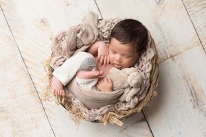 Newborn photography with rustic wooden props and neutral tones.