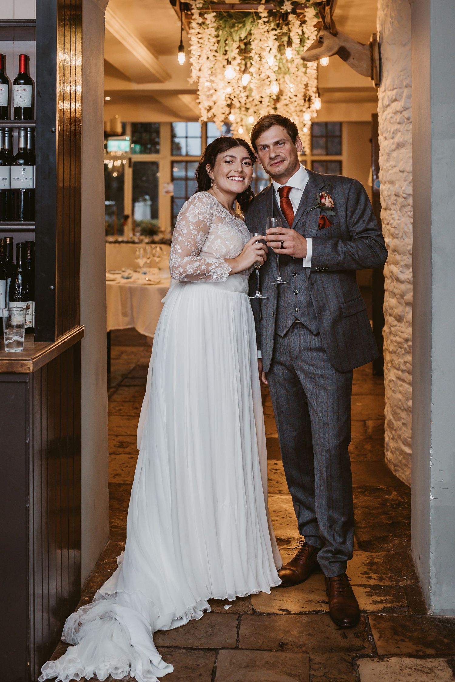A celebratory toast in an elegant venue with hanging floral decorations.