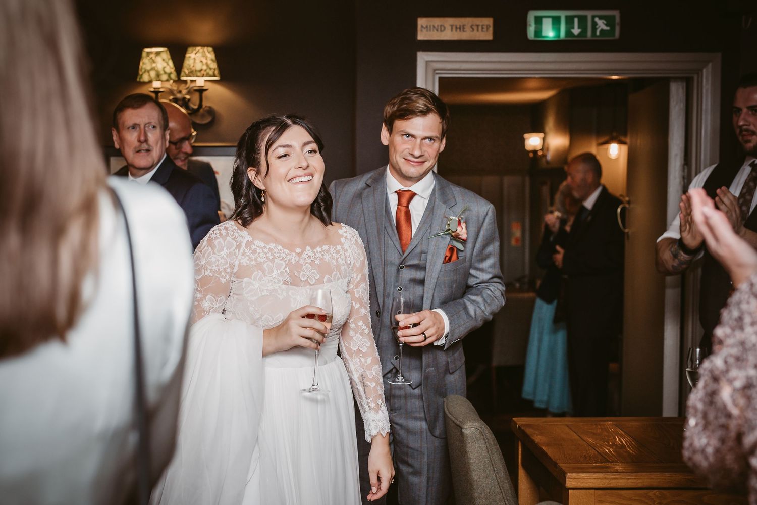 Wedding guests mingling and socializing during an indoor reception celebration.