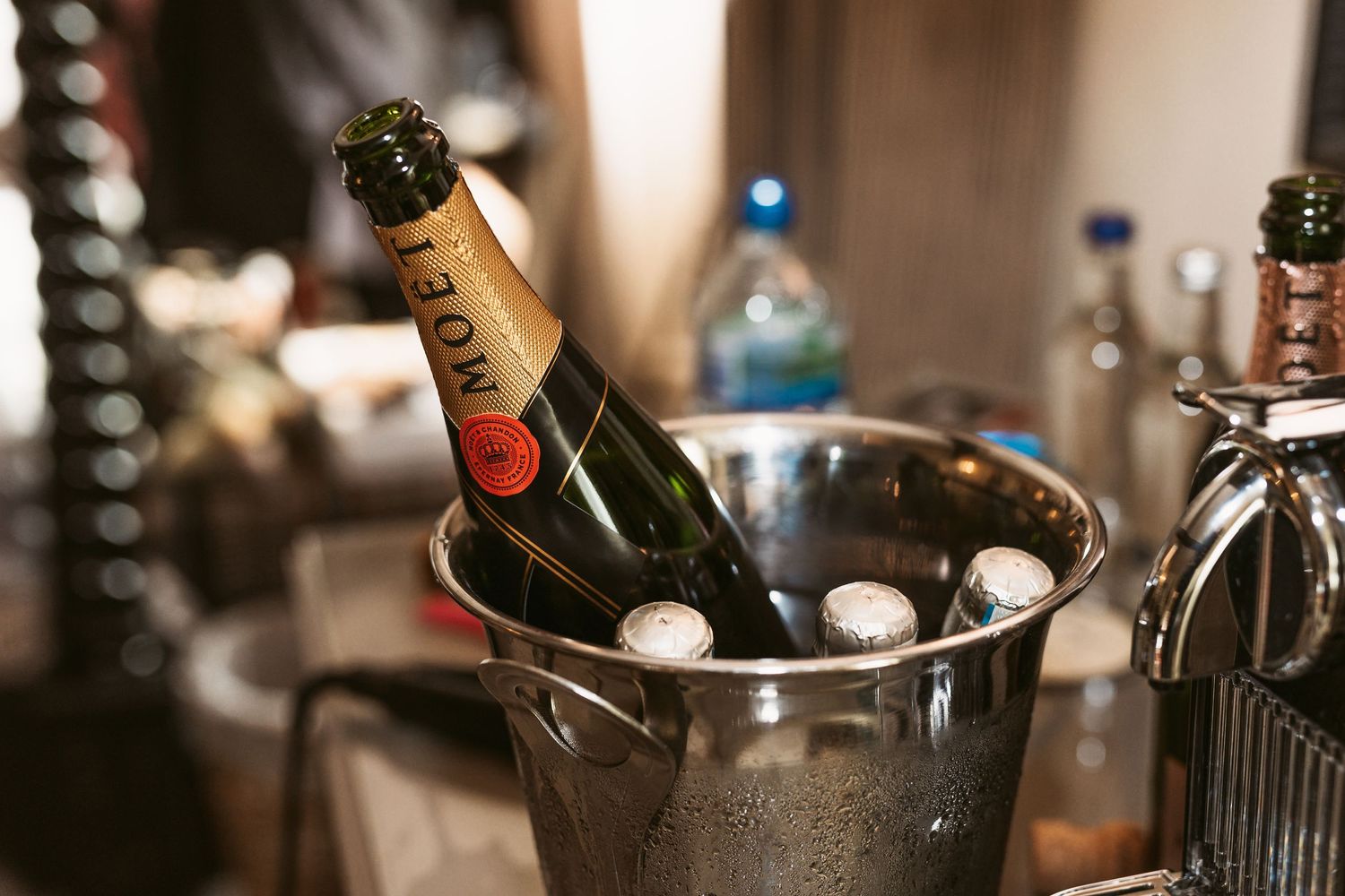 Champagne bottle chilling in an ice bucket with other beverages.