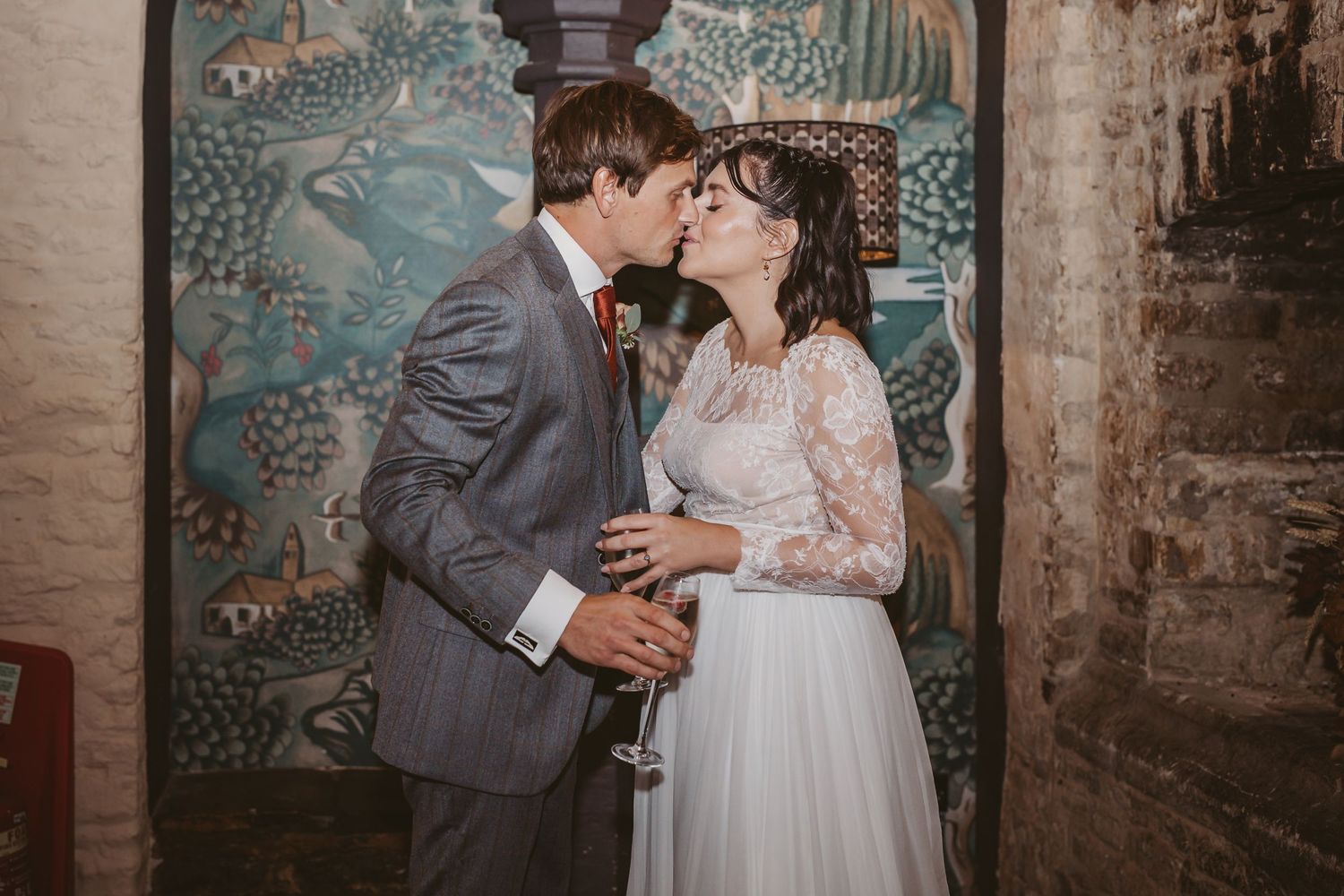 A romantic moment shared against a decorative wall mural background.