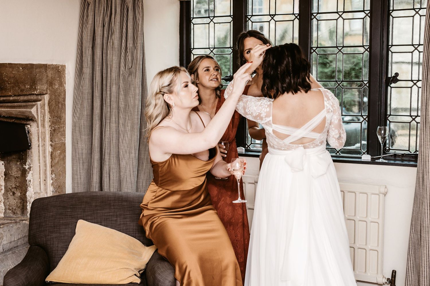 Wedding party members in elegant dresses share a joyful moment.