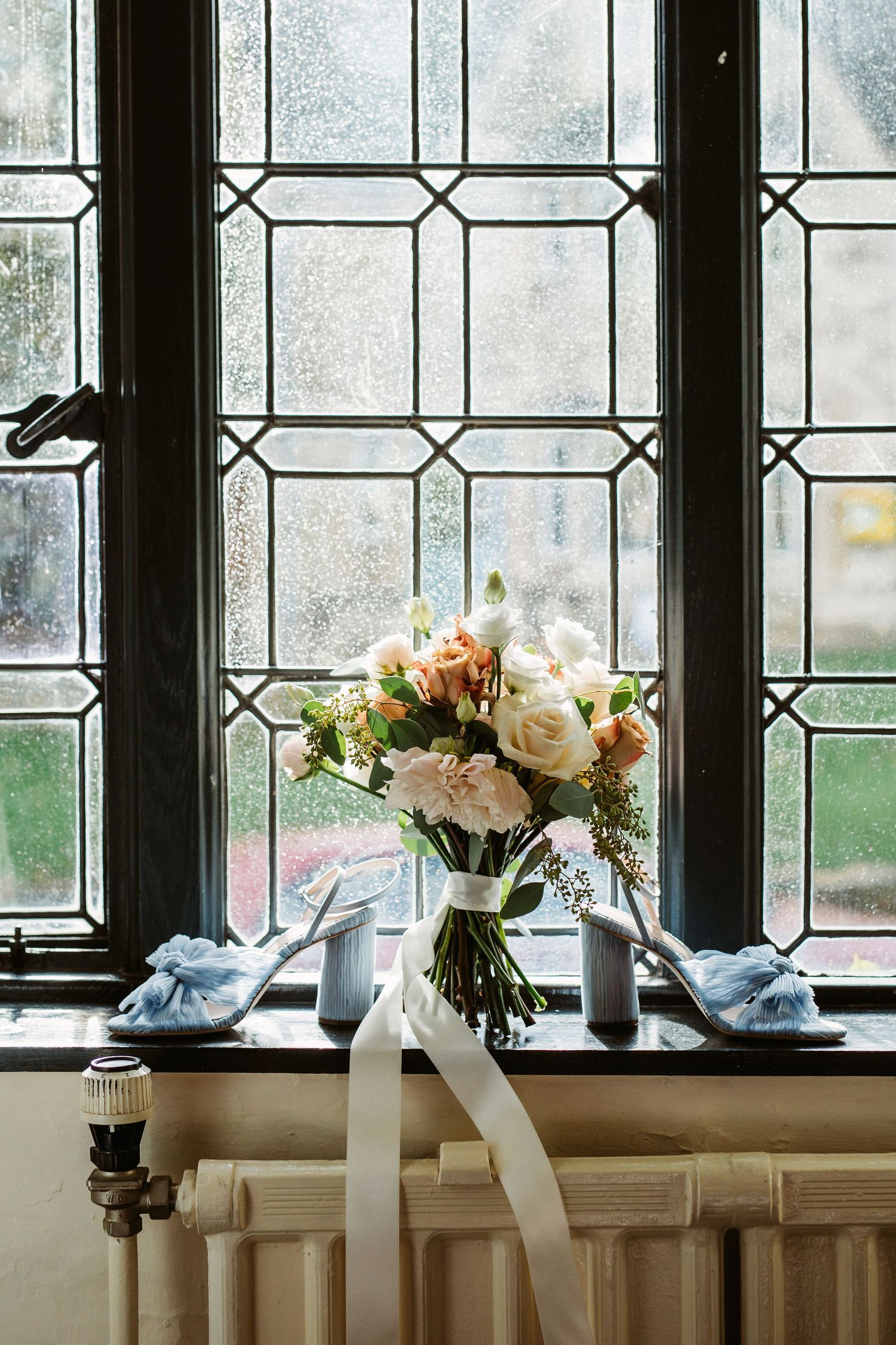 Elegant bouquet of pink and white flowers against a geometric window pane.