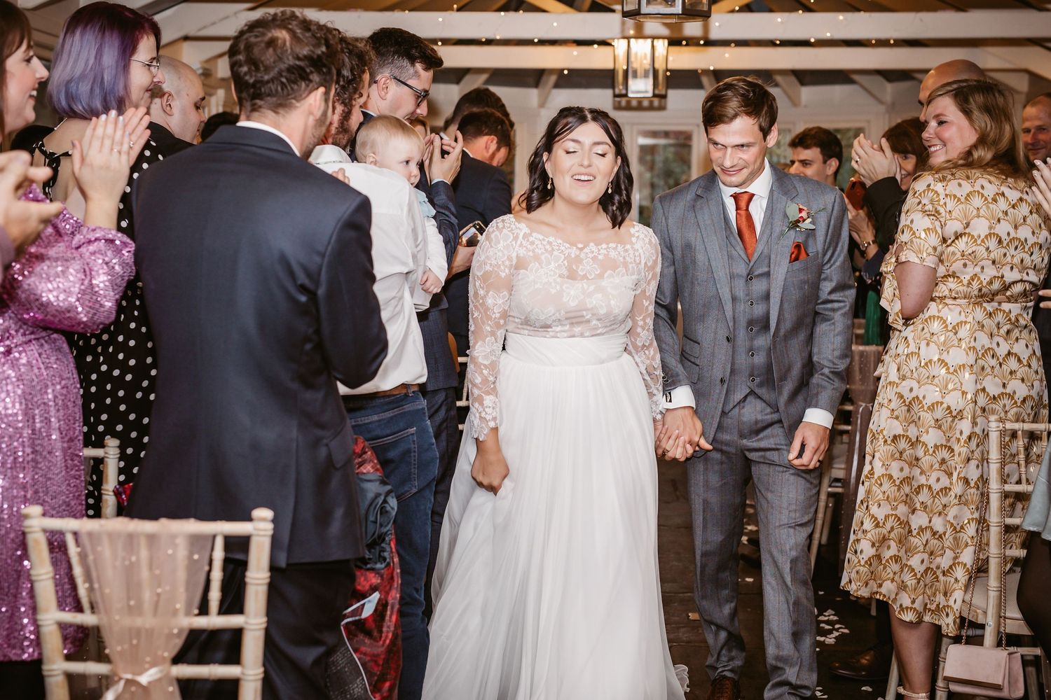 Guests celebrate during a wedding reception in an elegant indoor setting.
