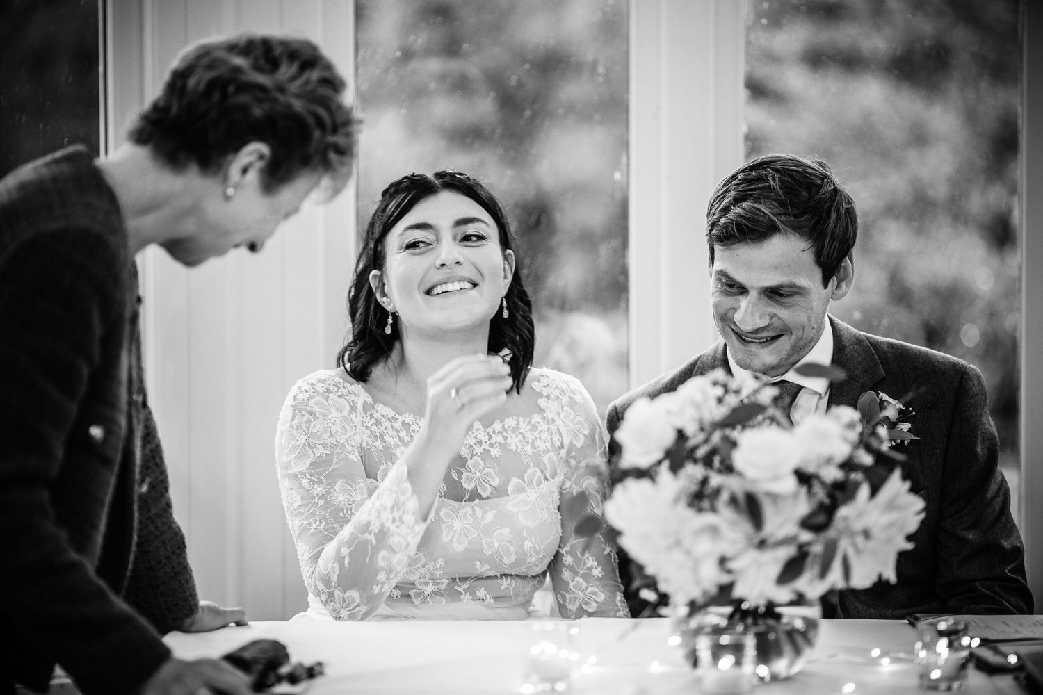 A candid black and white moment during a wedding ceremony signing.