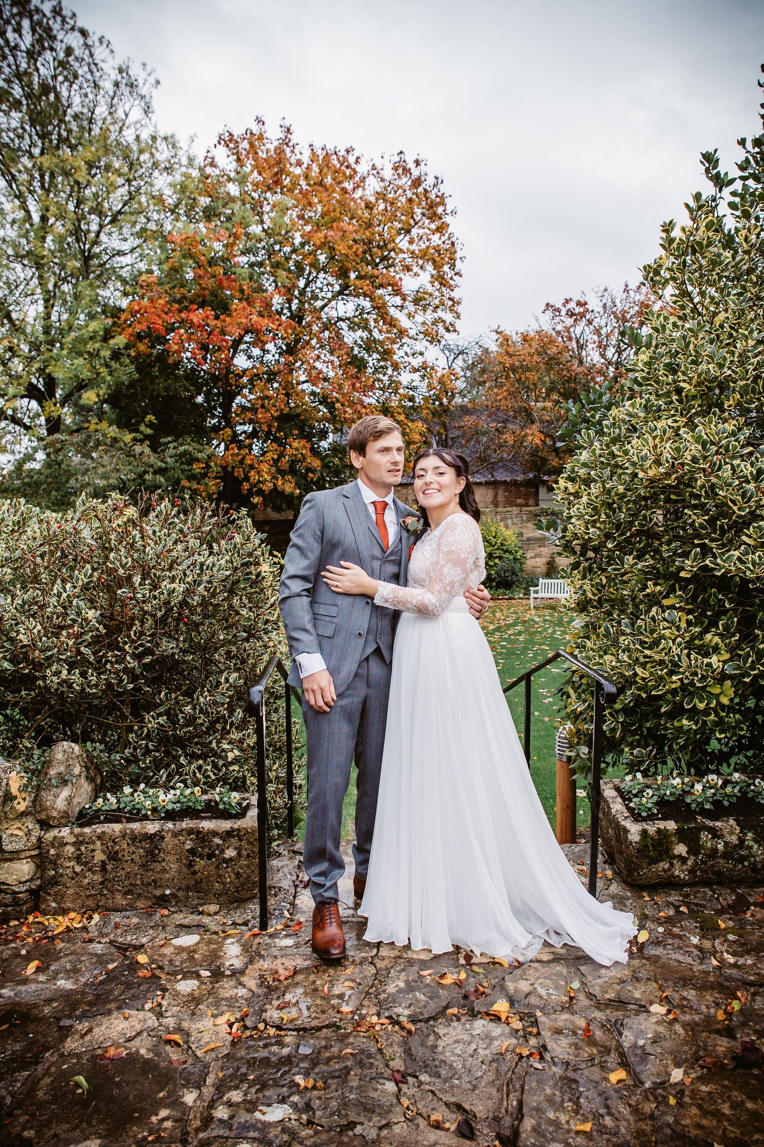 A couple shares an intimate moment during their fall wedding photoshoot in a garden setting.