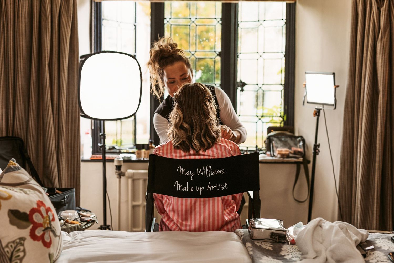 Getting ready in a bright room with salon chair and professional lighting setup.