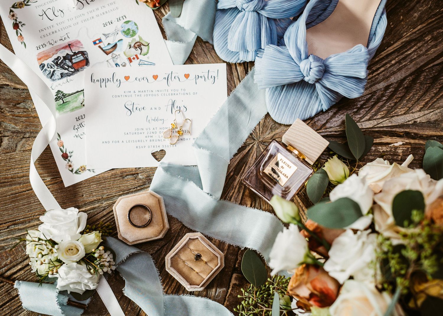 Wedding stationery and decorative elements arranged with blue ribbon and floral details.