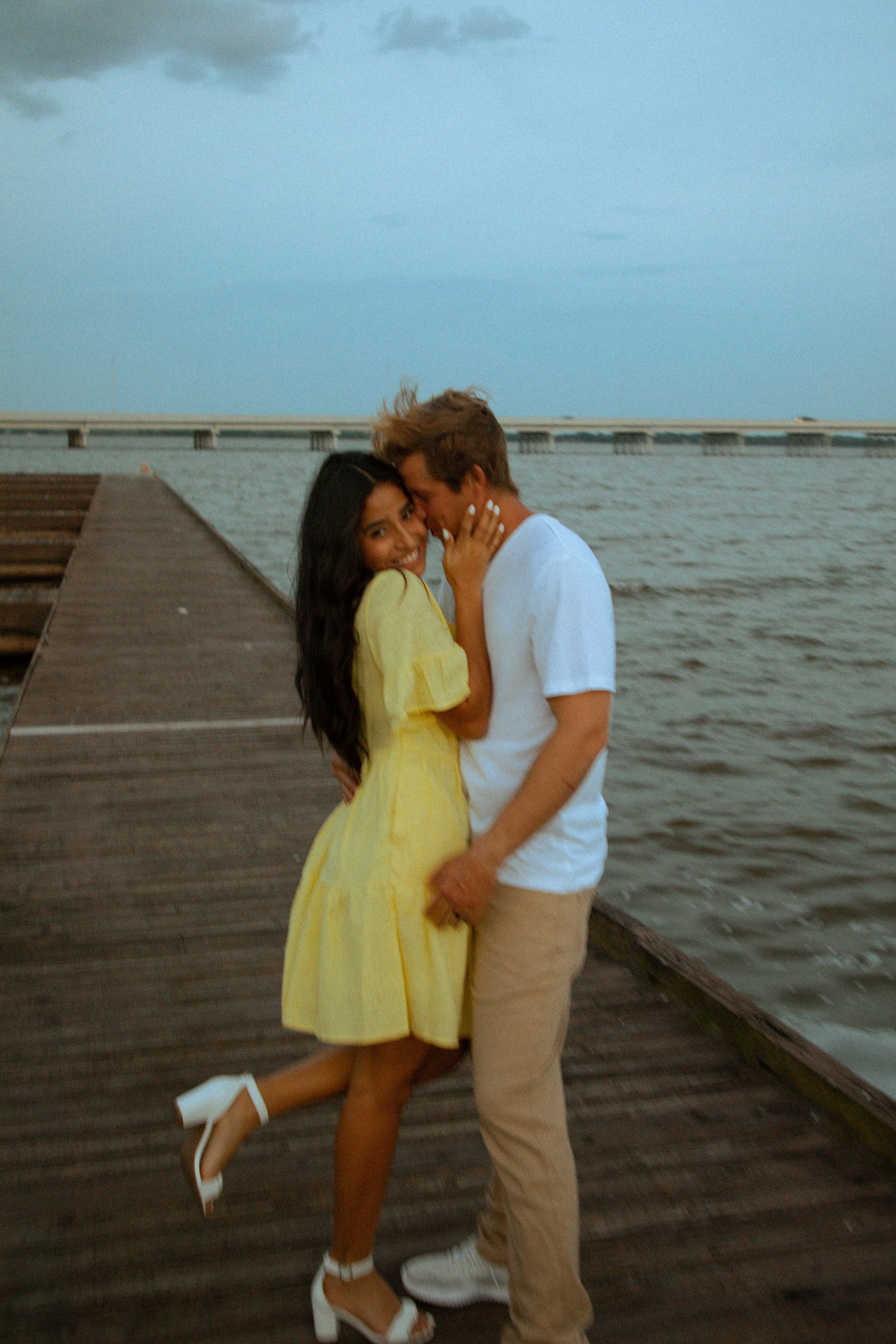A romantic seaside moment on a wooden pier at sunset.