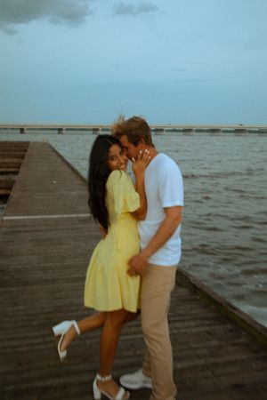 A romantic seaside moment on a wooden pier at sunset.