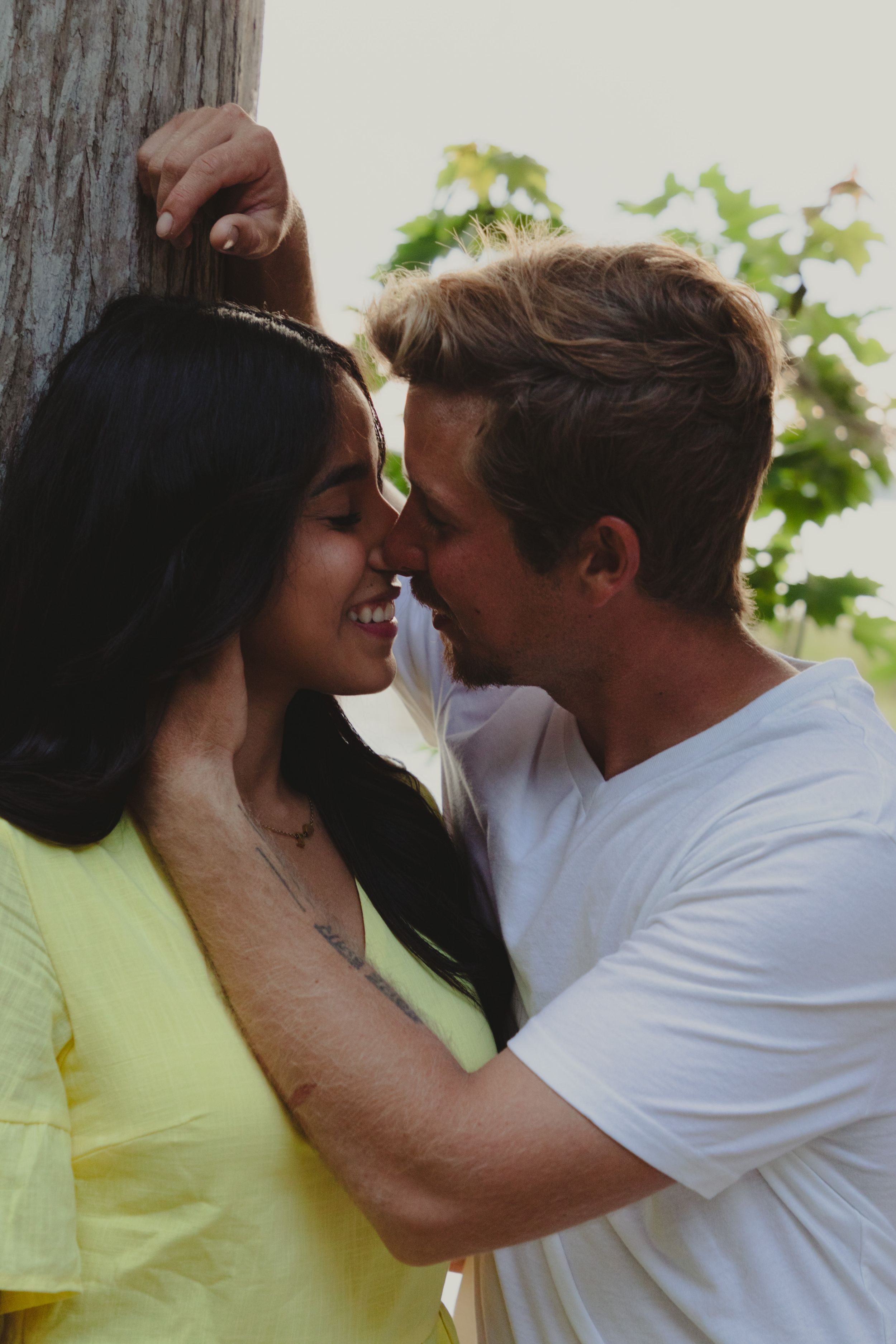 A romantic couple in yellow and white outfits share intimate moments in a series of close-up photos.