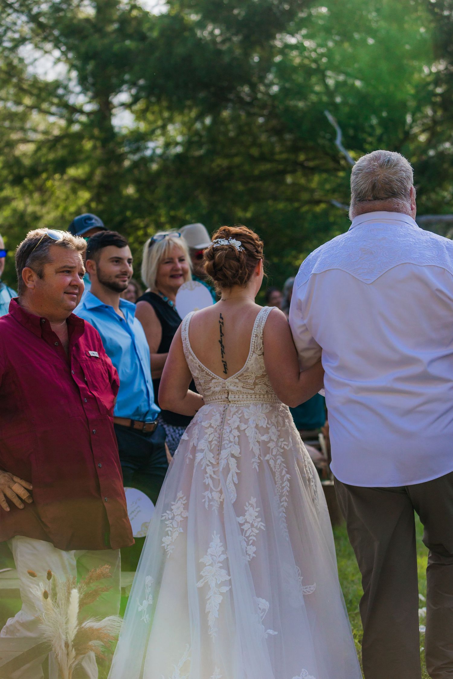 Outdoor wedding reception gathering with guests in garden setting.