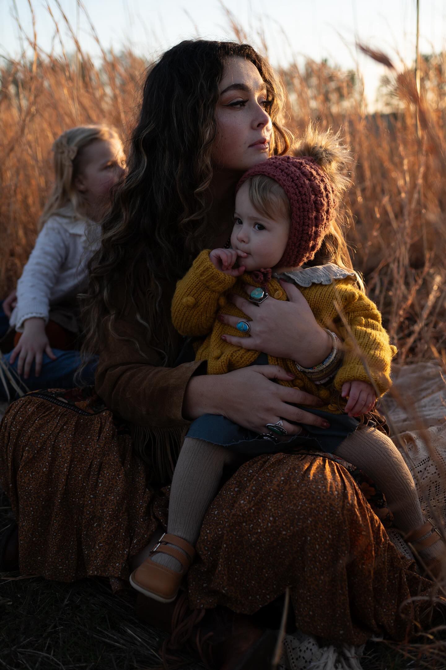 Tender moments captured in autumn field with warm lighting and tall grass.