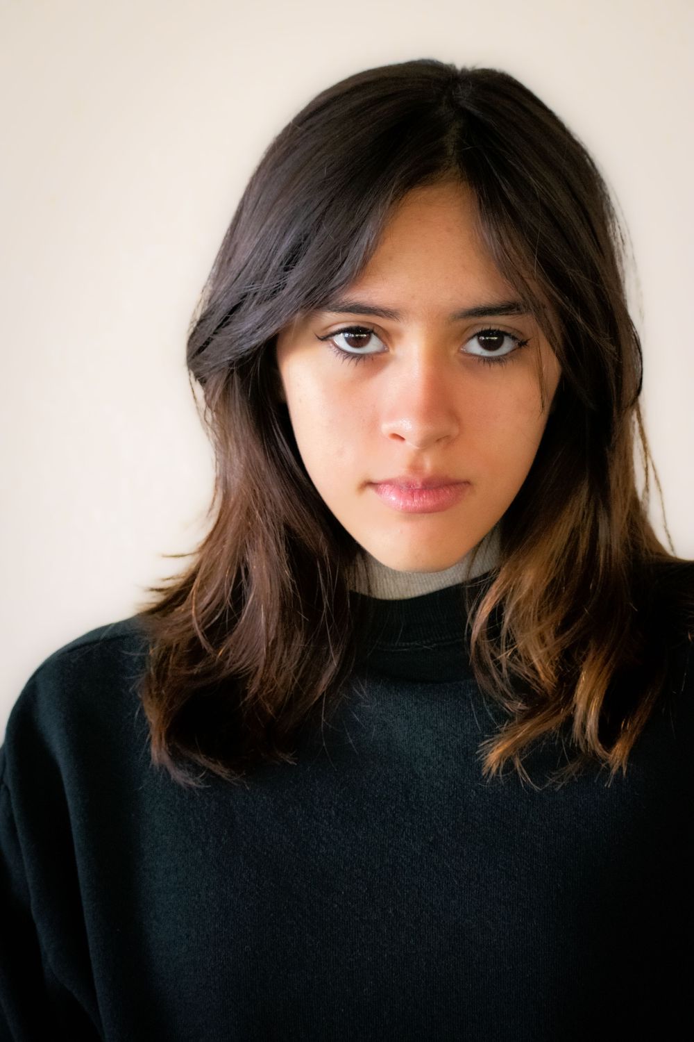 Portrait series showing person in black turtleneck against white background.