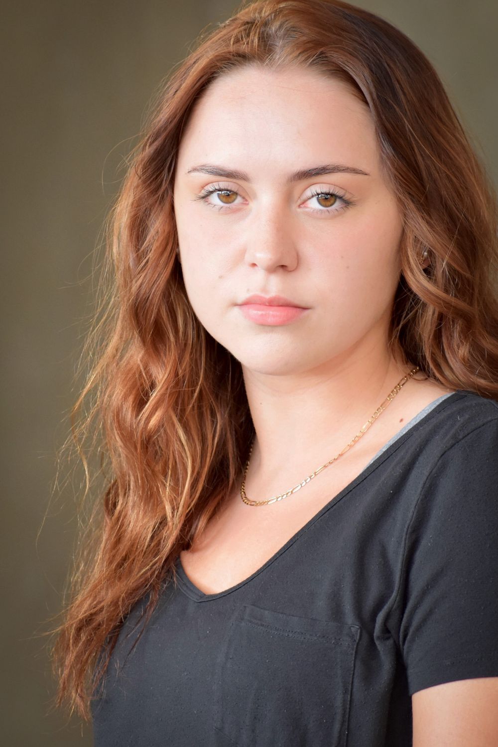 Portrait of someone wearing black shirt against neutral background.
