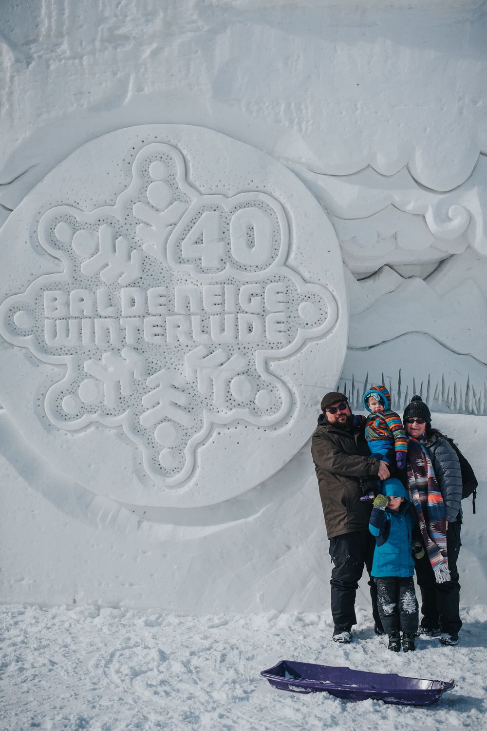 Winterlude family photograph in front of a big snow wall.