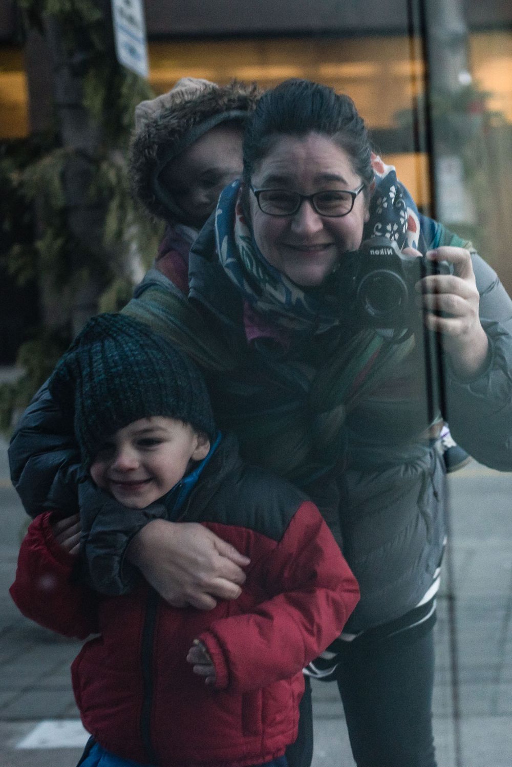 Photo taken of a reflection as mom tries to get in the picture too.