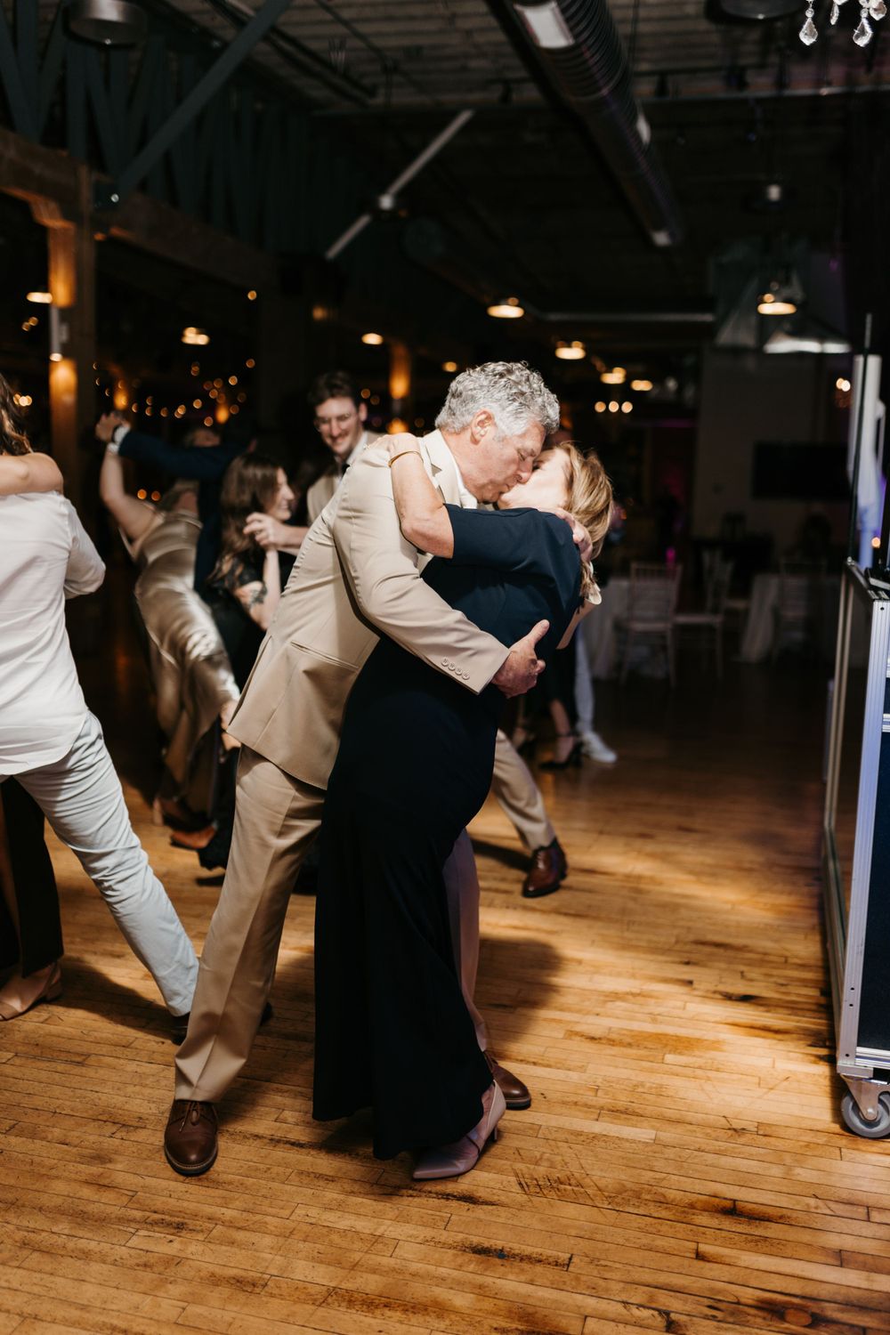 Couple sharing a romantic dip on the dance floor at an elegant wedding reception.