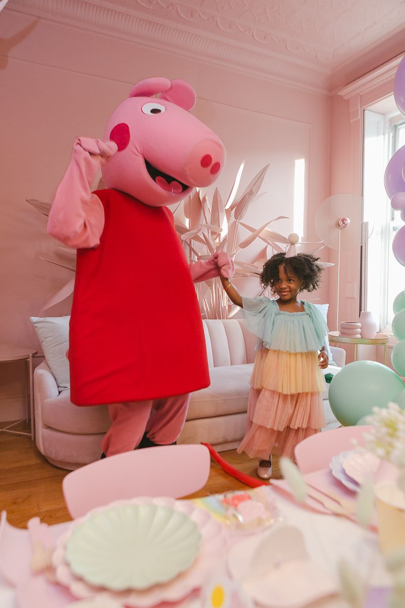 a candid view of a girl dancing with Peppa pig at her birthday party in Brooklyn, photo by Paula Ortiz NYC Family Photos