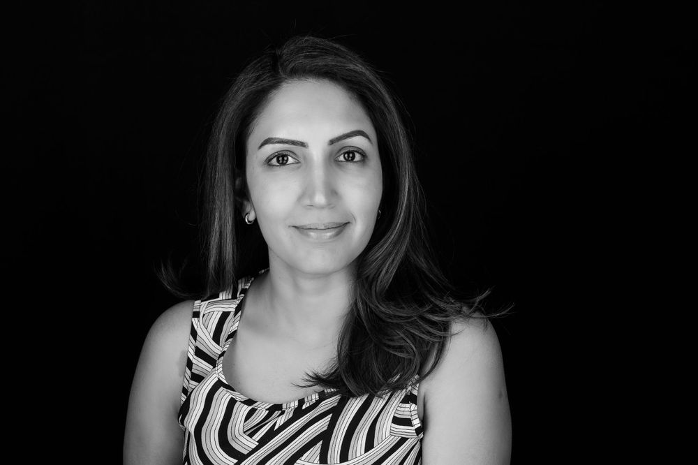 Professional headshot with zebra print dress against dark background.