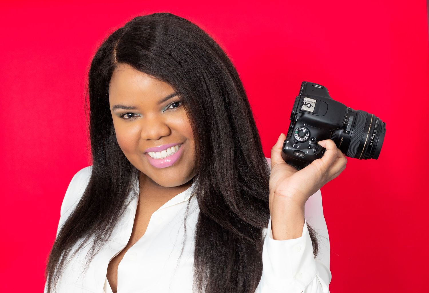 Professional headshot against a red background of a photographer.