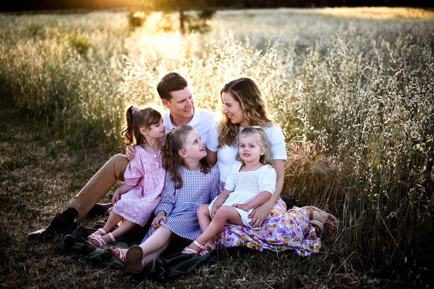 Family Mum Dad 3 young girls sitting in the field at sunset Dubbo Photographer
