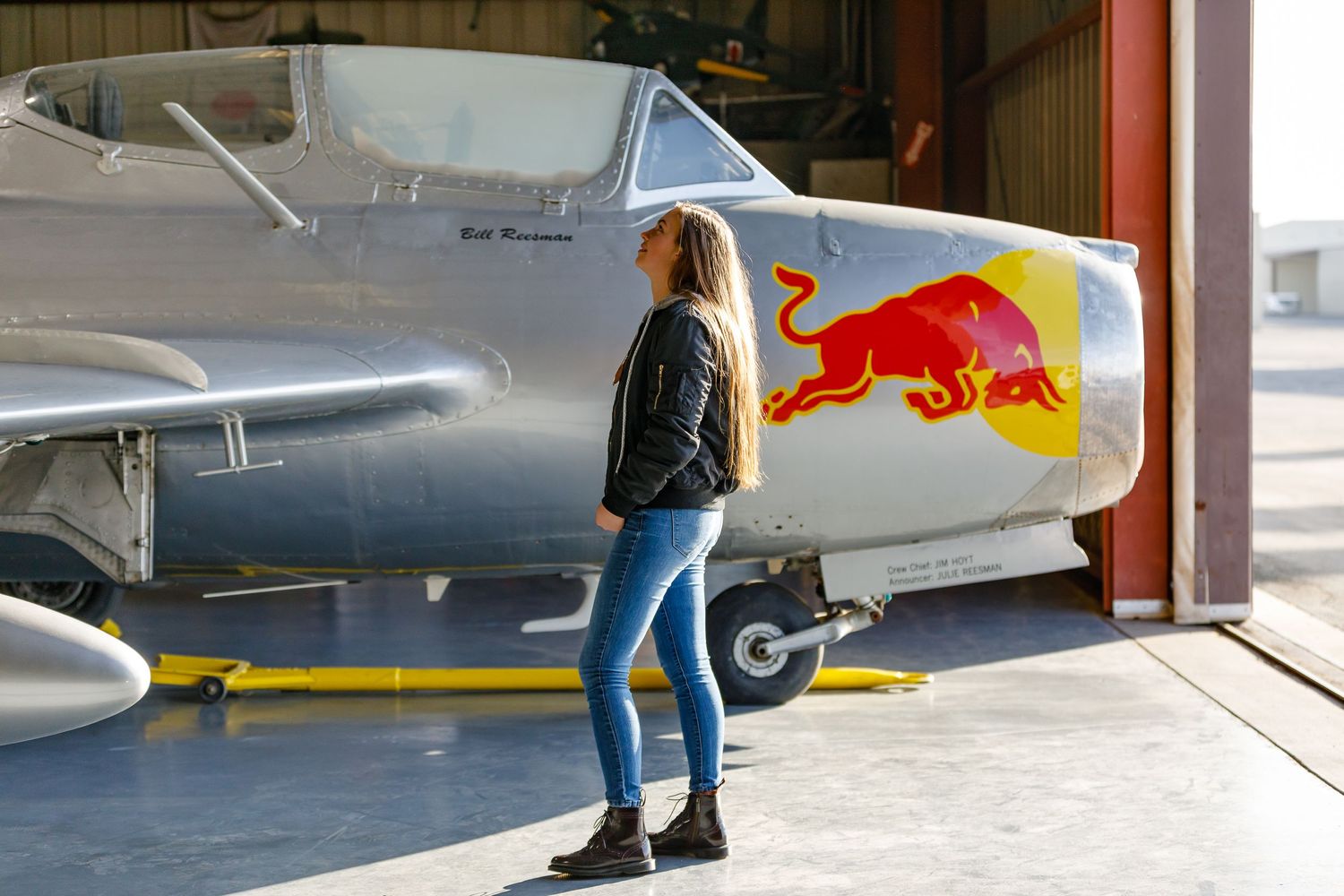 Girl standing near Red Bull airplane