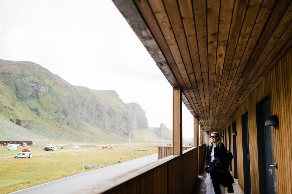 Covered wooden balcony walkway overlooking dramatic cliffs and mountains in Iceland.
