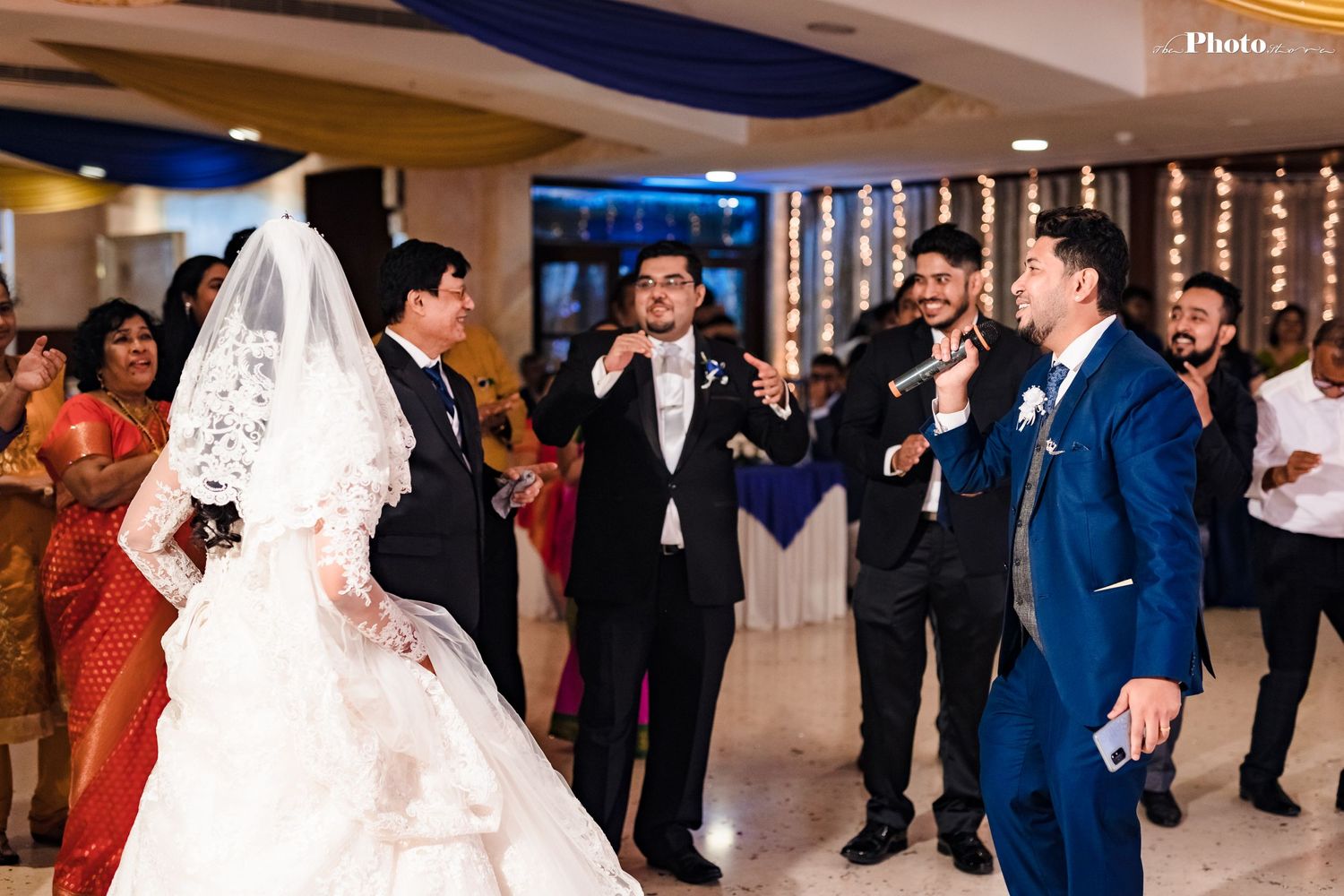 Wedding celebration with bride in ballgown and guests gathered around during reception.