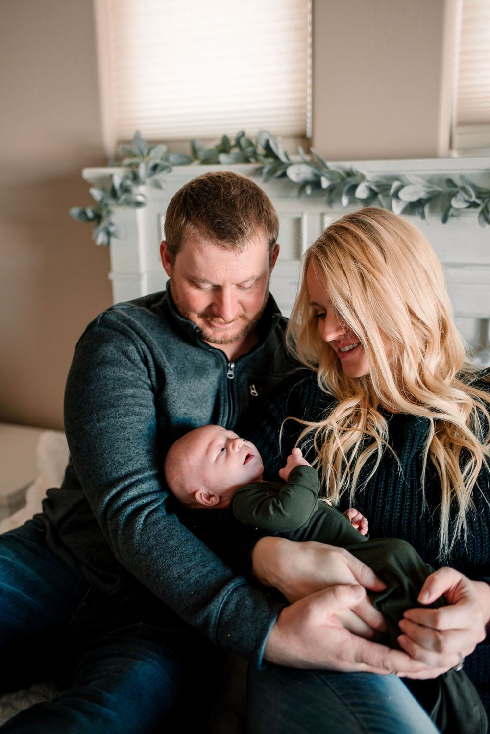 Family moment captured in front of a mantel decorated with eucalyptus garland.