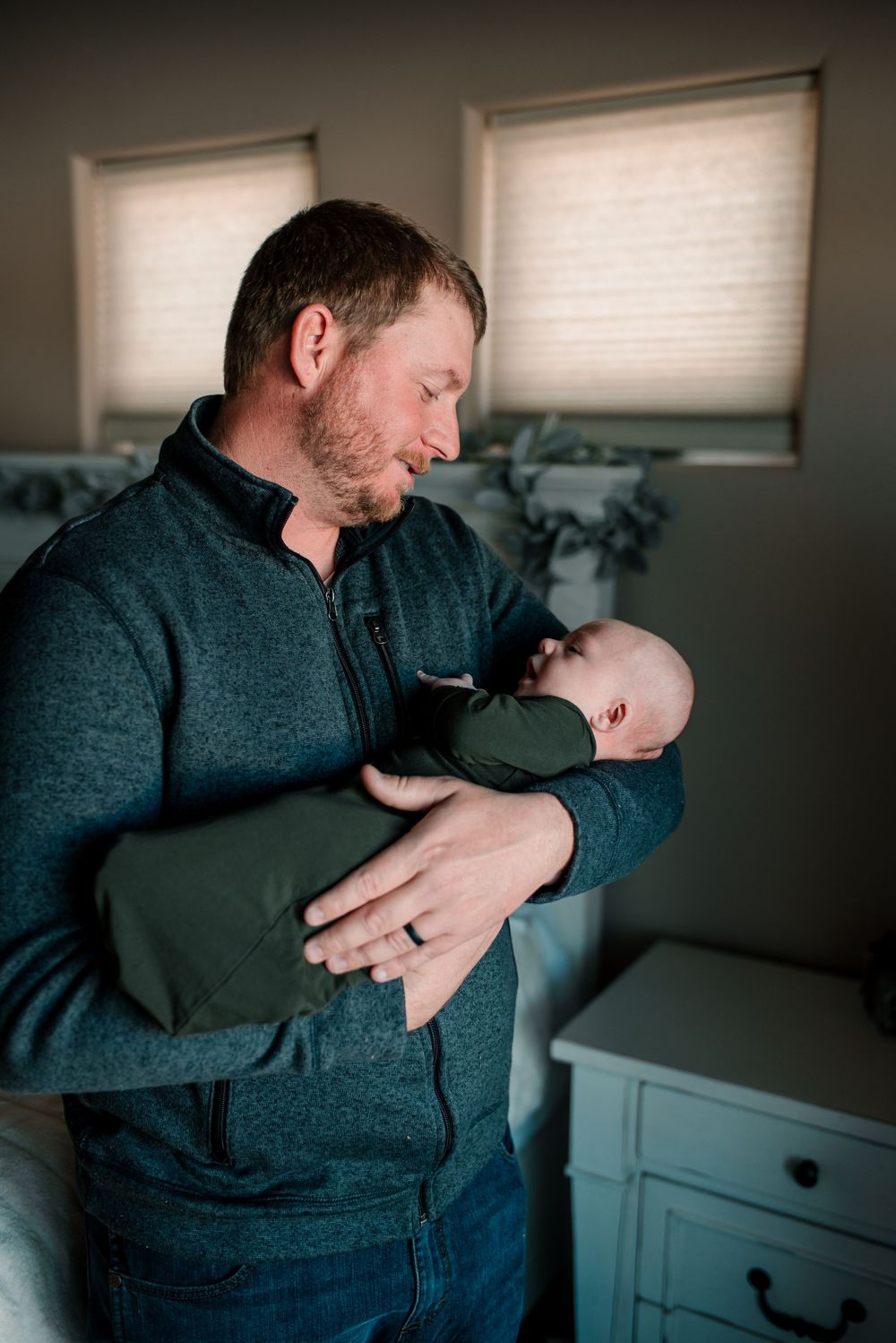 Sweet family moments captured in natural light against a grey wall and white furniture.