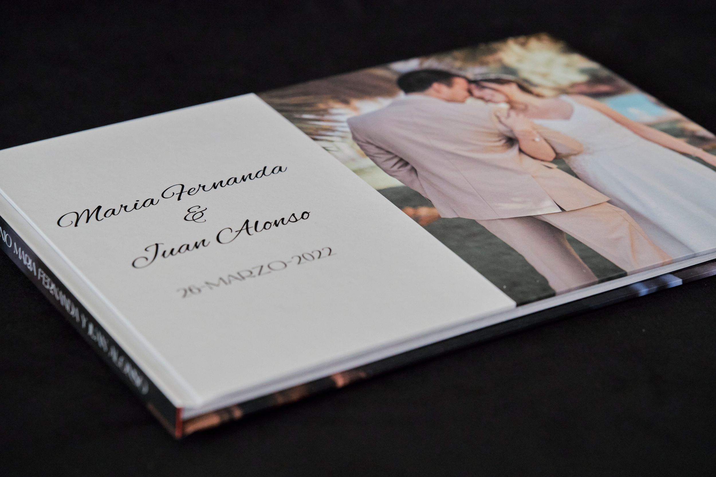 Elegant wedding photo album with names and date displayed on white cover.