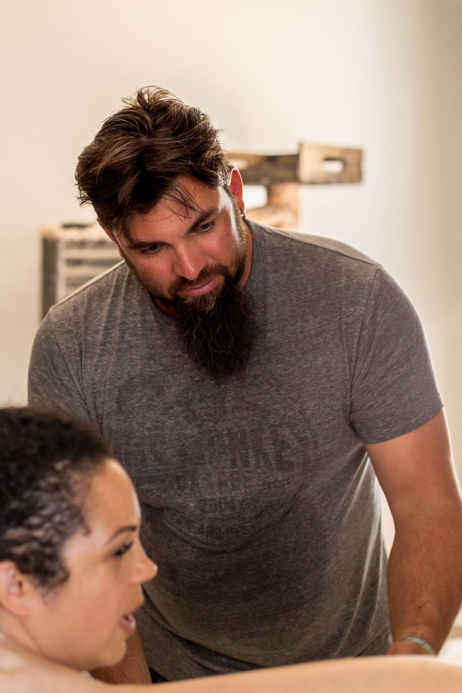 A supportive scene during a home birth with medical professionals attending to the laboring mother.