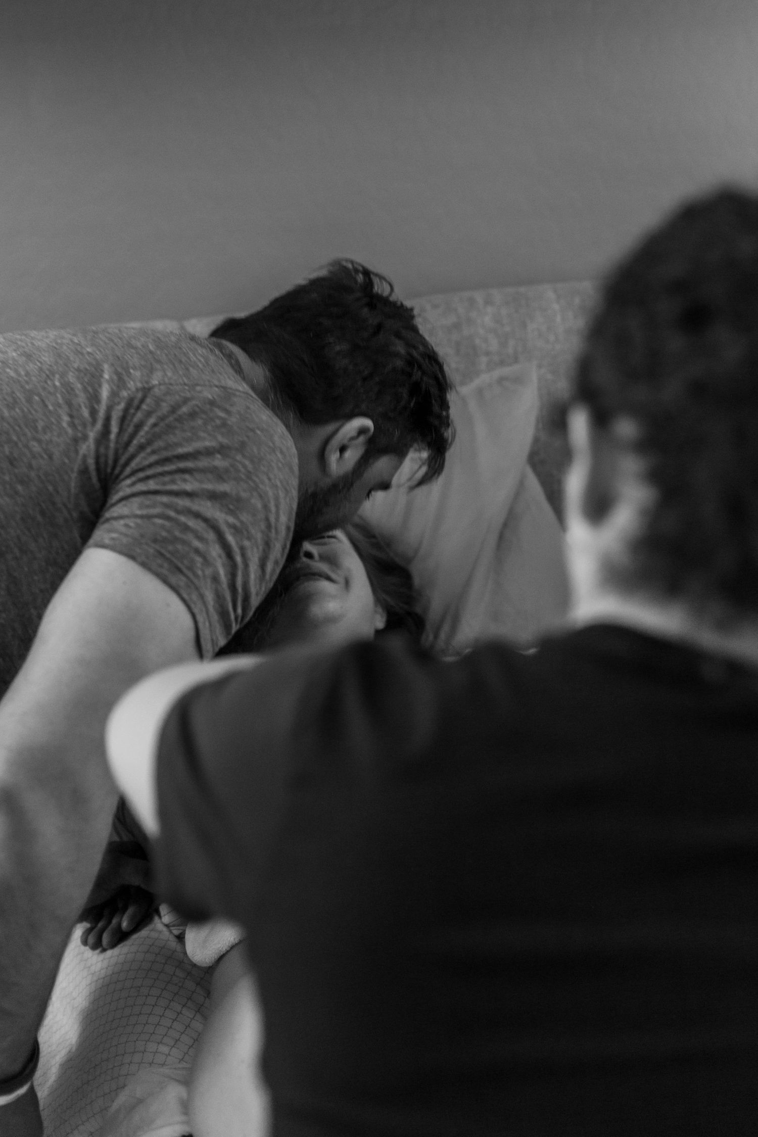 A black and white capture of an intimate birthing moment with medical support present.