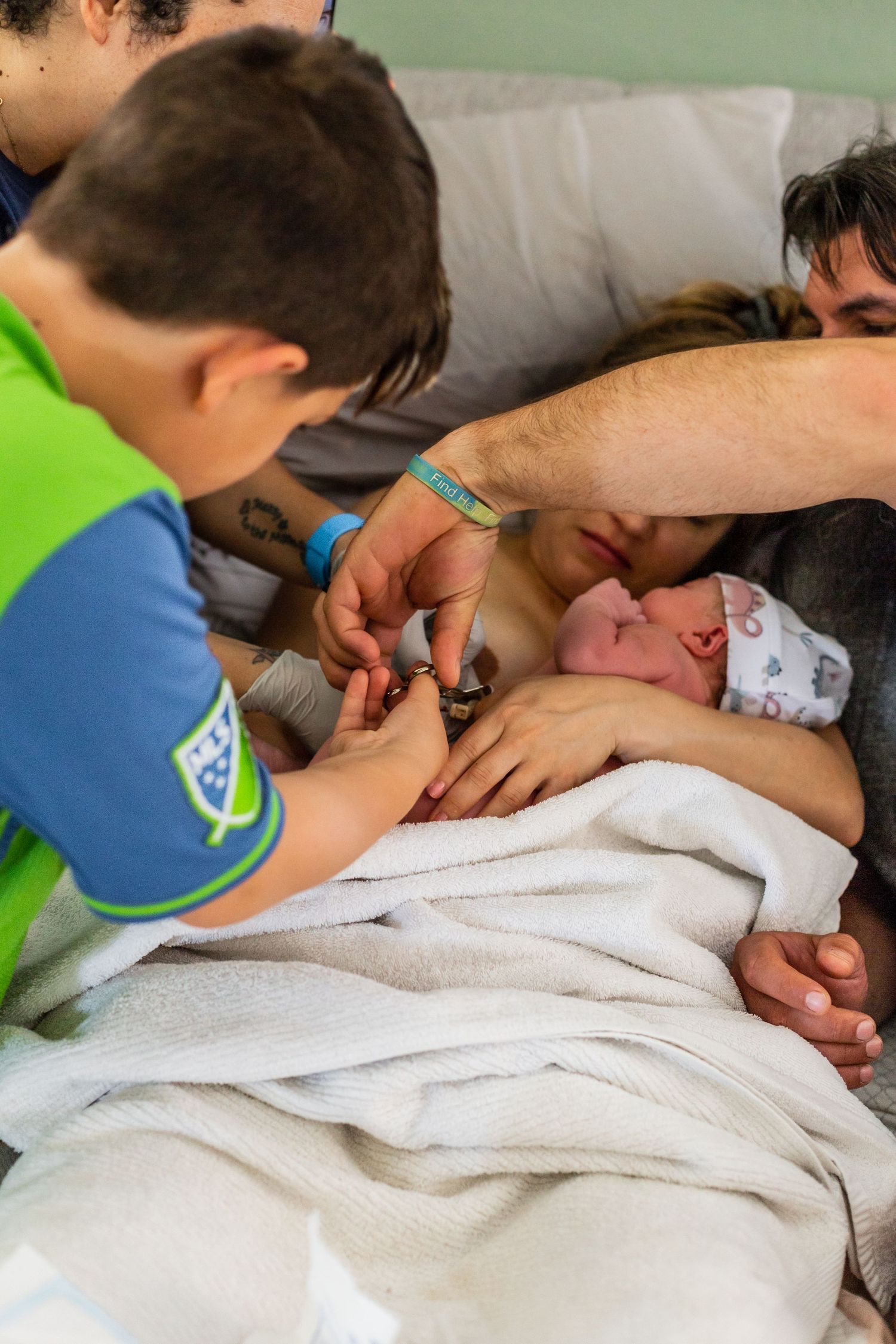 Intimate birth photography showing first moments with newborn in hospital setting.