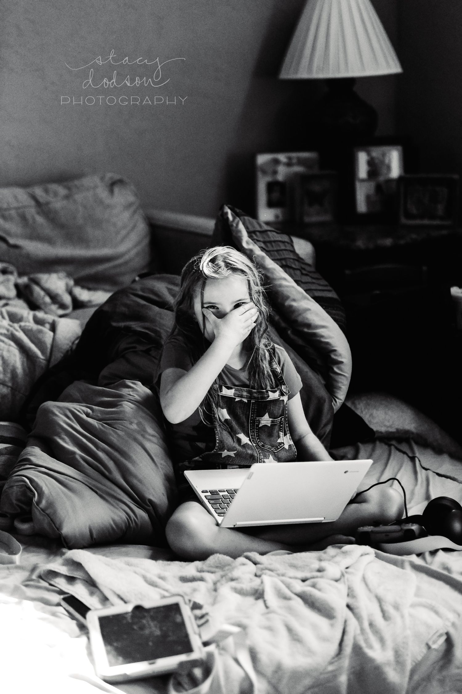 Black and white image of girl covering part of her face with her hand