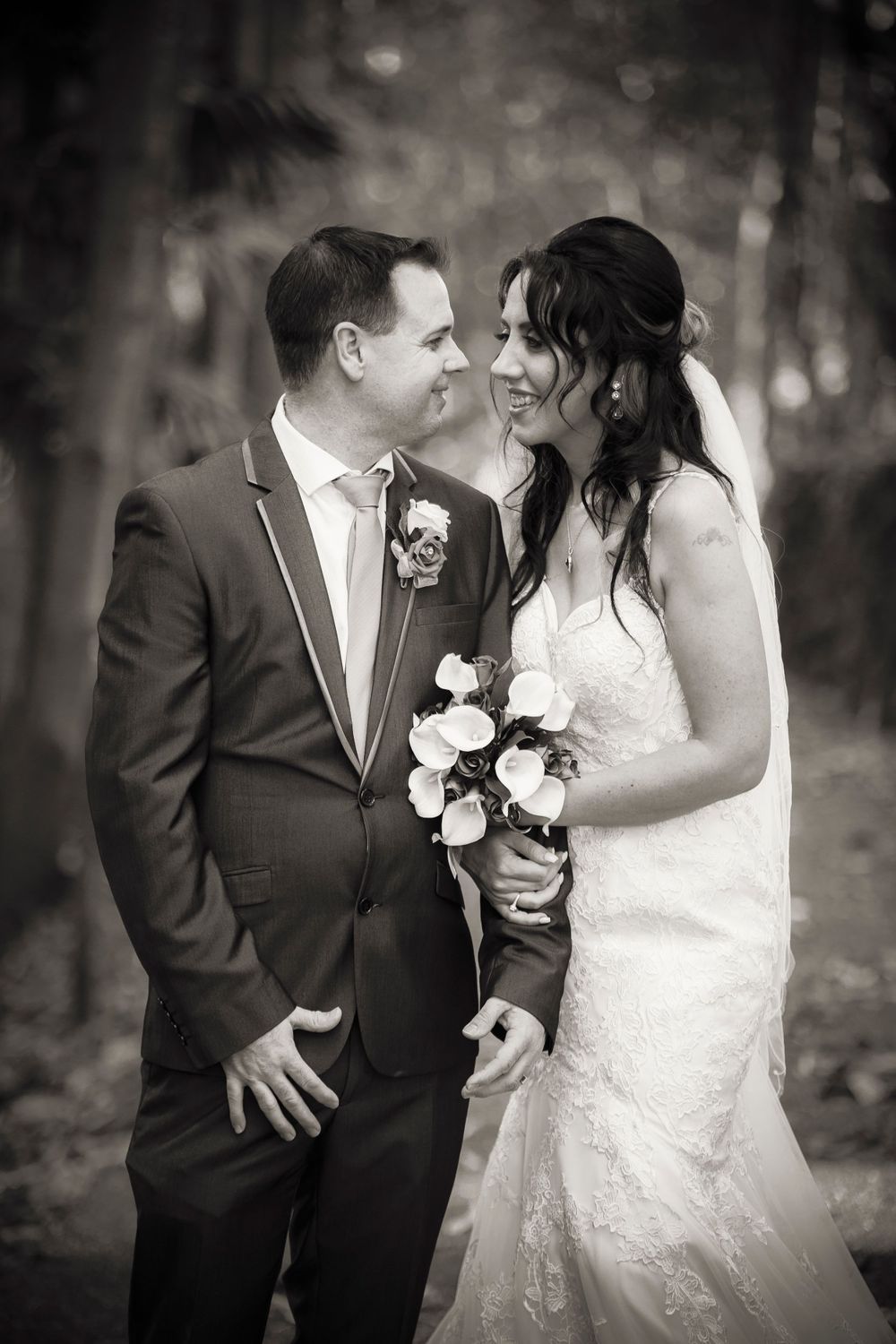 Black and white wedding portrait showcasing tender moment between newlyweds.
