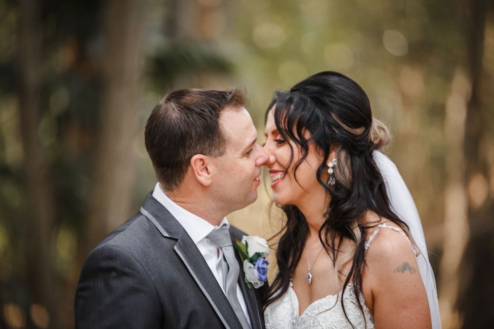 Tender moment captured between newlyweds during forest wedding photoshoot.