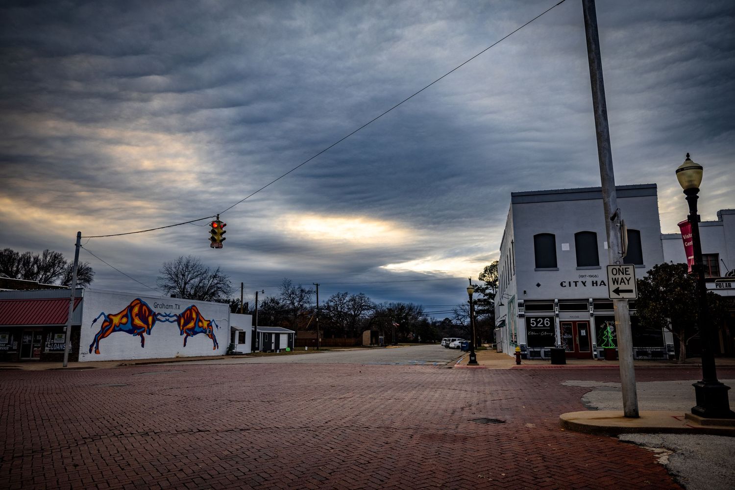 Small town street view with vintage buildings and lamp posts at dusk.
