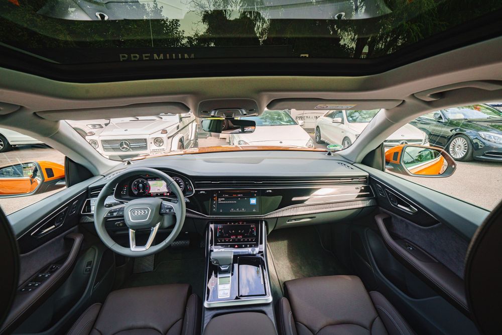 Driver's perspective of Audi Q8 interior showing digital instrument cluster and center console.