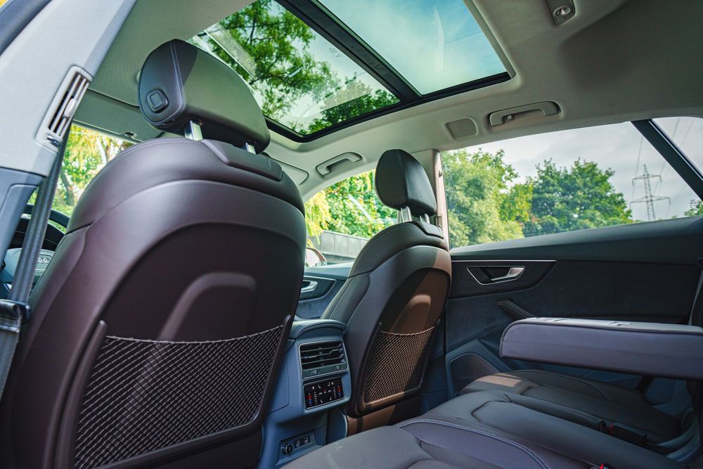 Rear seat view of Audi Q8 interior showing panoramic sunroof and leather upholstery.