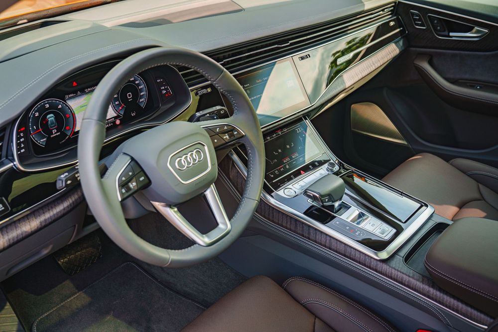 Modern Audi dashboard featuring digital displays and leather-wrapped steering wheel.