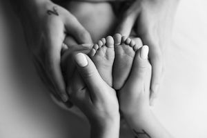 Mom holding her newborn's feet showing how small they are.