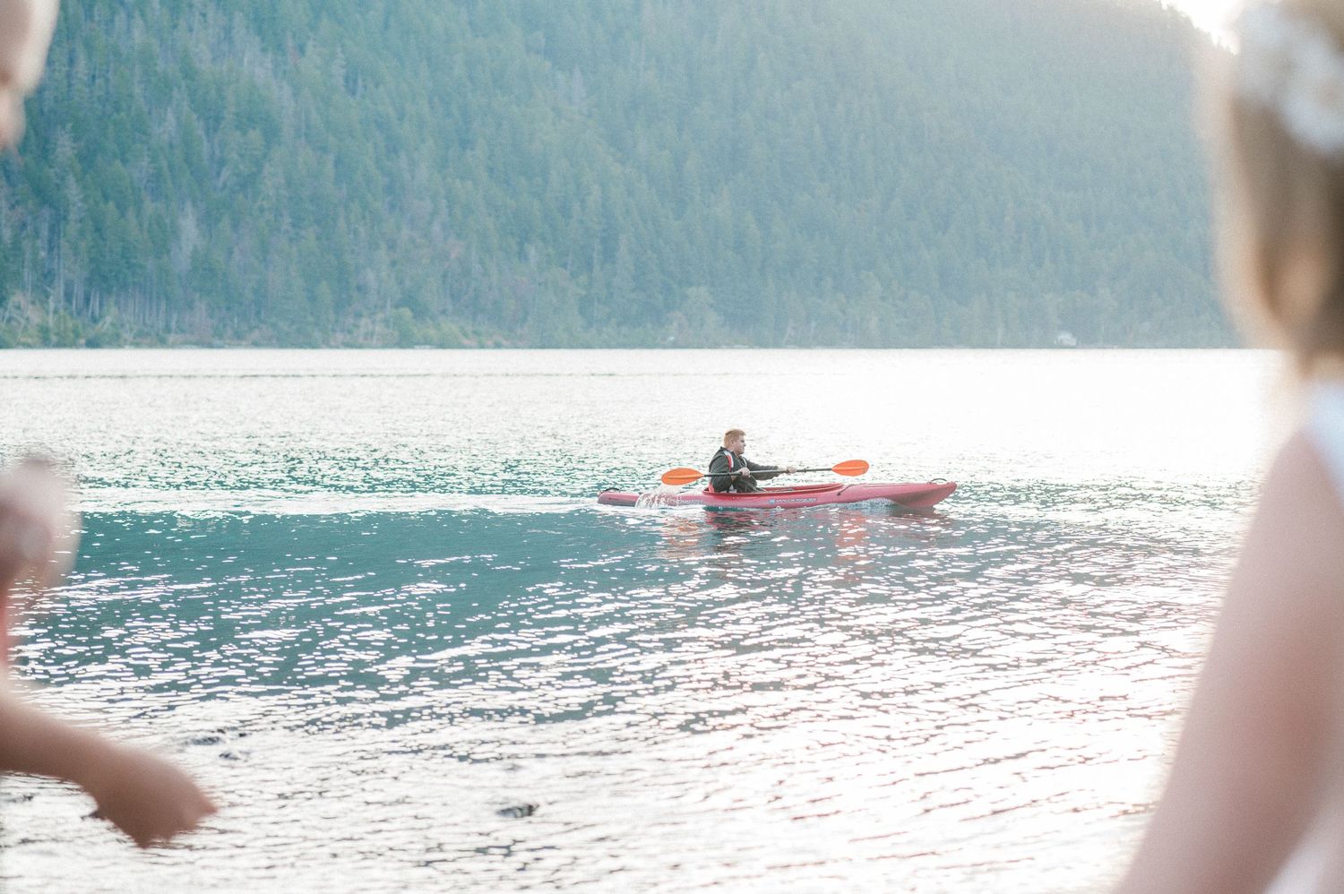kayaker on a bright blue lake during a sunny day