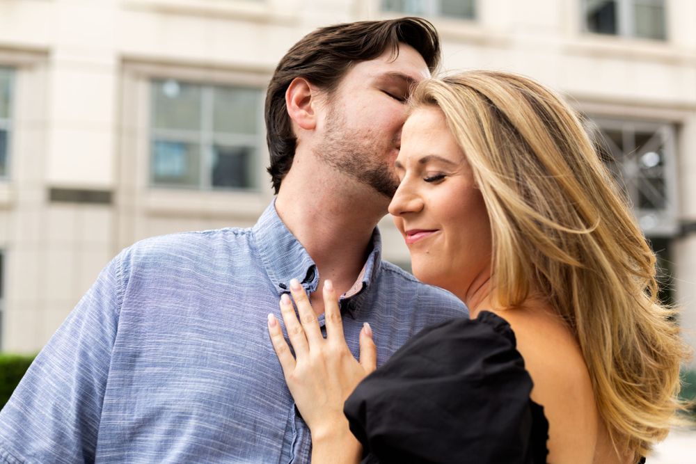 Tender moment between couple against urban architecture background.