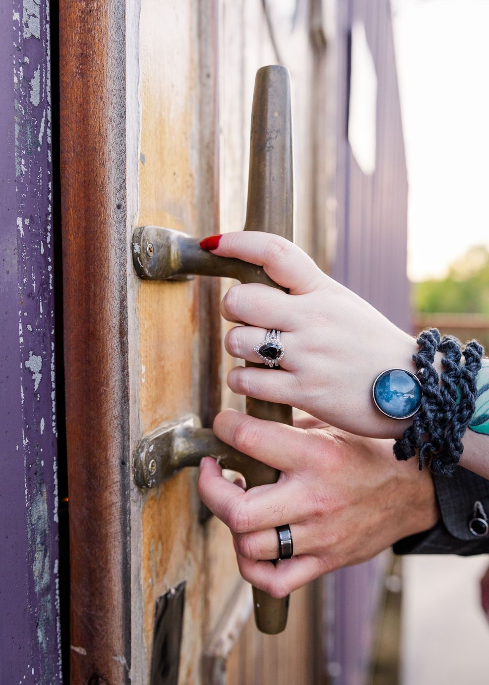 couples hands holding door handle