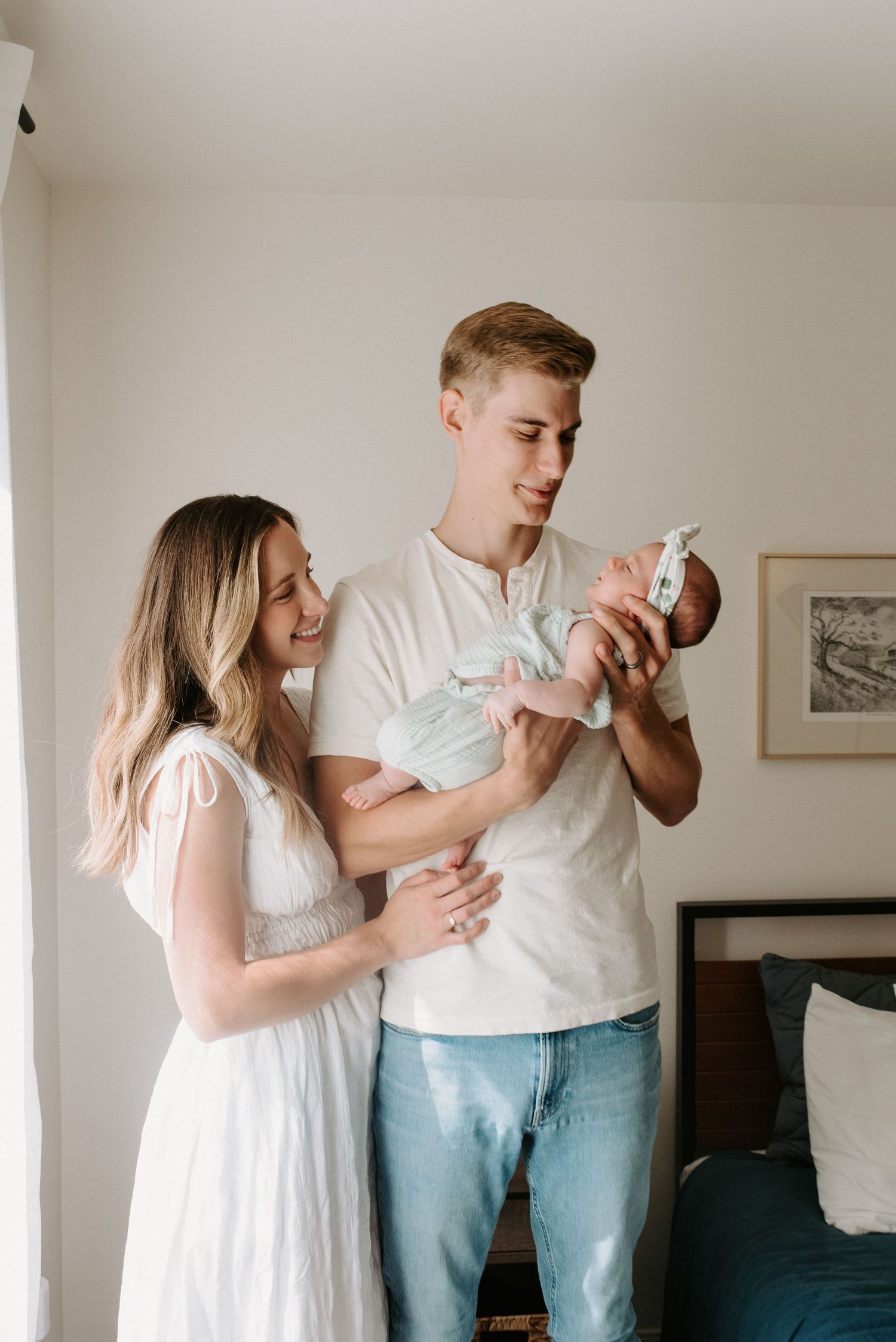 Bright indoor photoshoot showing tender family moments with newborn baby.