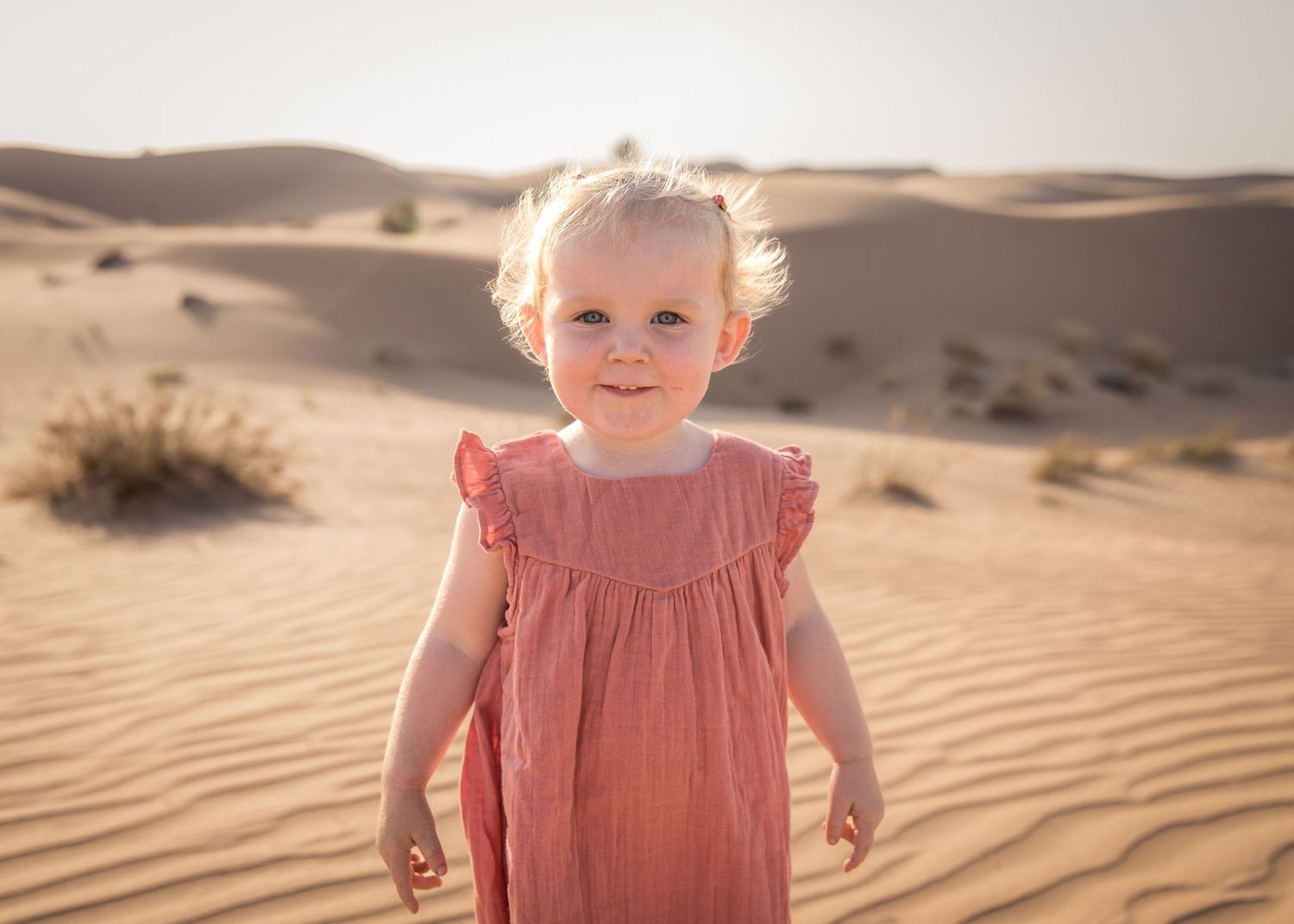Little girl in Orange dress against the desert backdrop